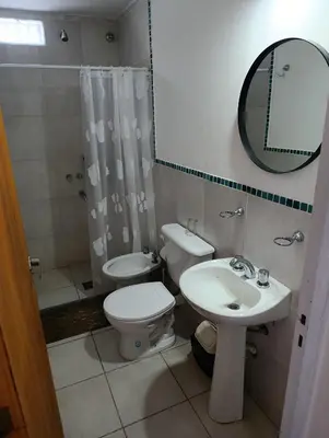 a bathroom with a toilet and a sink and a mirror at Departamentos Talamuchita in Santa Rosa de Calamuchita