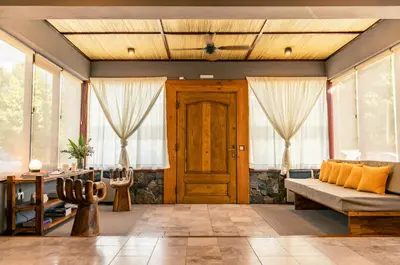 a living room with a wooden door and windows at Hotel Chapaqñan in Villa Rumipal