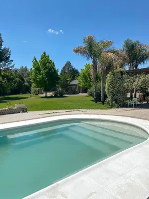 a large swimming pool in a yard at Hotel Chapaqñan in Villa Rumipal