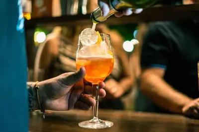 a person is pouring a drink into a glass at Hotel Chapaqñan in Villa Rumipal