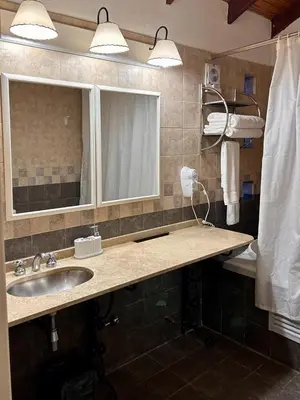 a bathroom with a sink and a mirror at Hotel Chapaqñan in Villa Rumipal