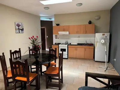 a kitchen and dining room with a table and a refrigerator at La Morena in Villa Carlos Paz