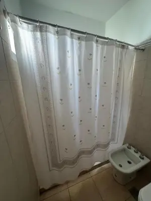 a bathroom with a shower curtain and a toilet at La Morena in Villa Carlos Paz