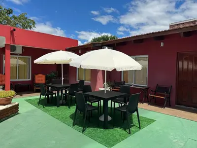 two tables and chairs with umbrellas on a patio at La Morena in Villa Carlos Paz