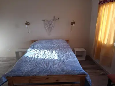 a bed with a blue comforter in a bedroom at Luz de las Sierras in Arroyo de Los Patos