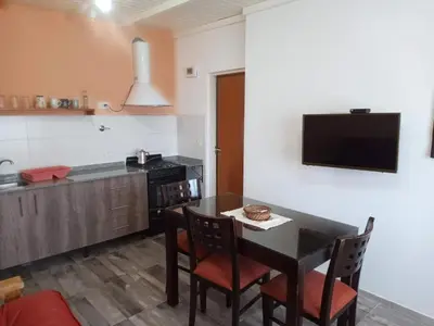 a kitchen with a table and chairs and a television at Luz de las Sierras in Arroyo de Los Patos