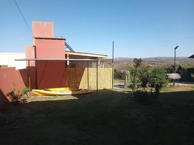 a house with a yellow kayak in a yard at Luz de las Sierras in Arroyo de Los Patos