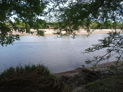 a body of water with a beach in the distance at Luz de las Sierras in Arroyo de Los Patos