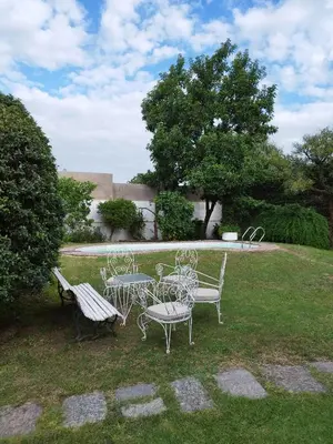 a table and chairs and a bench in a yard at CERRO LOFT in Cordoba
