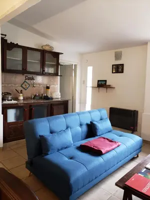 a blue couch in a living room with a kitchen at CERRO LOFT in Cordoba