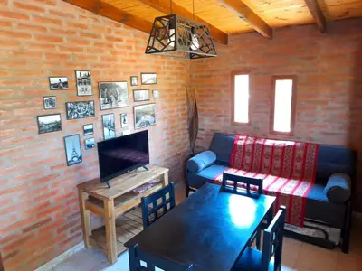 a living room with a couch and a table at Cabaña EL ZORZAL de Villa del Dique in Villa del Dique