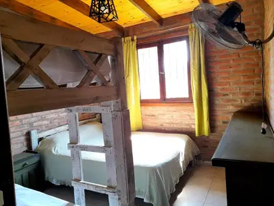 a bedroom with two bunk beds and a ladder at Cabaña EL ZORZAL de Villa del Dique in Villa del Dique