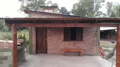 a brick building with a bench in front of it at Cabaña EL ZORZAL de Villa del Dique in Villa del Dique