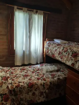 a bedroom with two beds and a window at Cabañas Stone Hill in Santa Rosa de Calamuchita