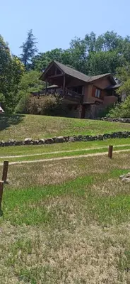 a house sitting on top of a grass field at Cabañas Stone Hill in Santa Rosa de Calamuchita