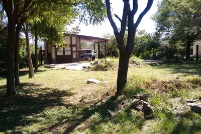 a house with a truck parked in a yard at Cabaña en Villa General Belgrano in Villa General Belgrano