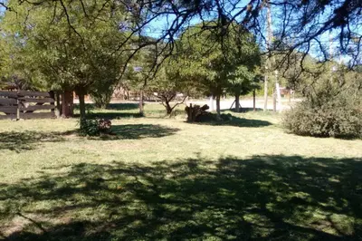 a field of grass with trees and a fence at Cabaña en Villa General Belgrano in Villa General Belgrano