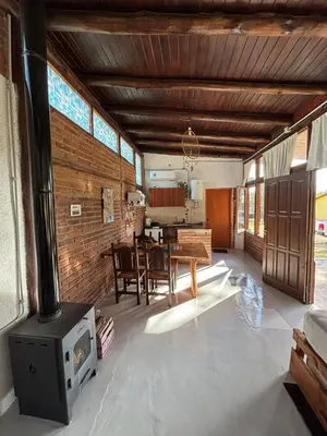 a living room with a stove and a dining room at Cabaña en Villa General Belgrano in Villa General Belgrano