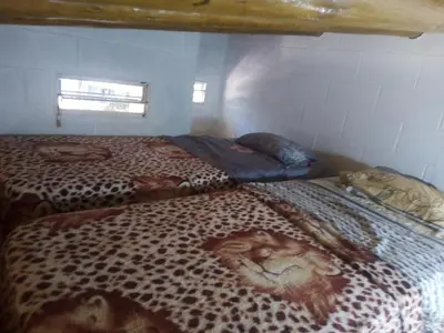 two beds in a room with a leopard print blanket at Cabaña en el lago in Trapiche