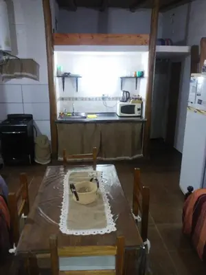 a kitchen with a wooden table and a microwave at Cabaña en el lago in Trapiche