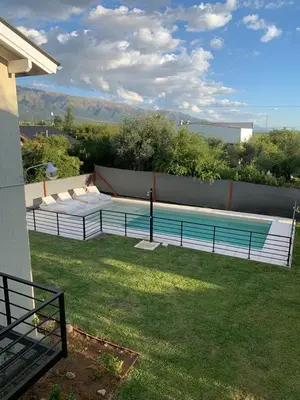 a swimming pool in a yard next to a house at Aires de Sierra in Merlo