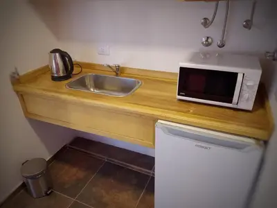 a kitchen with a sink and a microwave on a counter at Aires de Sierra in Merlo