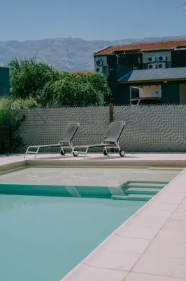 two chairs sitting next to a swimming pool at Aires de Sierra in Merlo