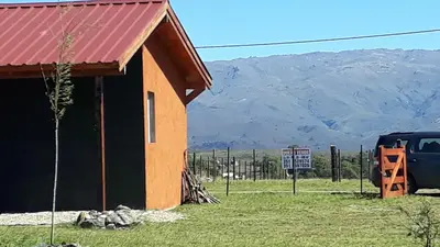 a building with a red roof next to a truck at Yacanto360 in Villa Yacanto