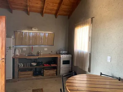 a kitchen with a table and a sink and a stove at Yacanto360 in Villa Yacanto