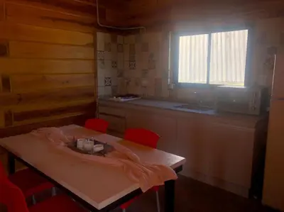 a kitchen with a wooden table with red chairs at Latitud 32 in Villa Yacanto