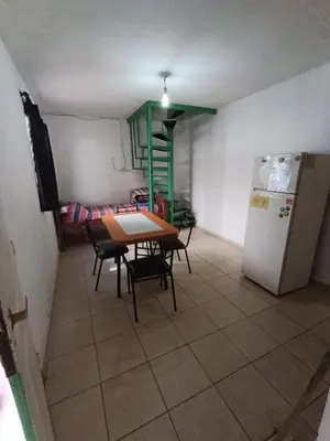 a small kitchen with a table and a refrigerator at La Vecindad in Cordoba