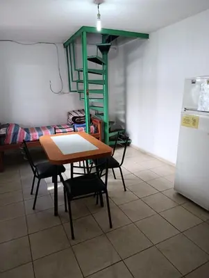 a kitchen with a table and chairs and a refrigerator at La Vecindad in Cordoba