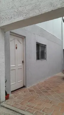 a white building with a white door and a window at La Vecindad in Cordoba