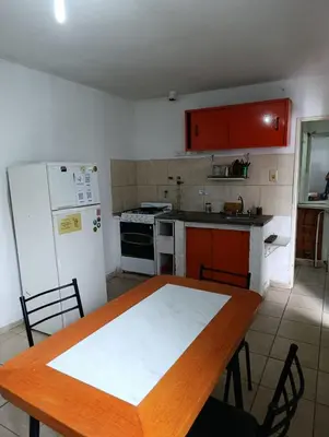 a kitchen with a wooden table and a refrigerator at La Vecindad in Cordoba