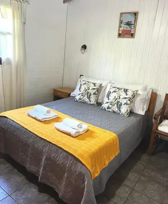 a bedroom with a bed with towels on it at Cabañas El Sauce Mina Clavero in Mina Clavero