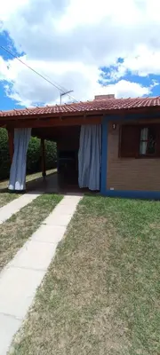 a house with a red roof with white curtains on it at Cabañas El Sauce Mina Clavero in Mina Clavero