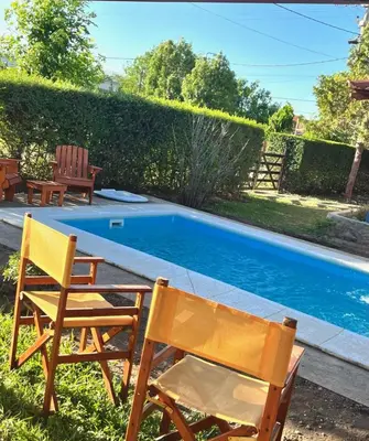 two chairs sitting next to a swimming pool at Cabañas El Sauce Mina Clavero in Mina Clavero