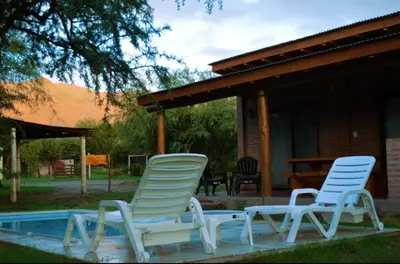 two lawn chairs sitting next to a pool at Cabaña Flor de Lis in San Javier
