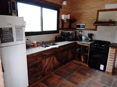 a kitchen with a white refrigerator and a sink at Cabaña Flor de Lis in San Javier