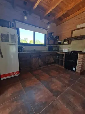 a large kitchen with a refrigerator and a window at Cabaña Flor de Lis in San Javier