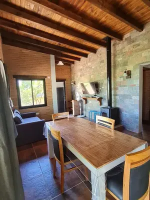 a dining room with a table and a living room at Cabaña Flor de Lis in San Javier