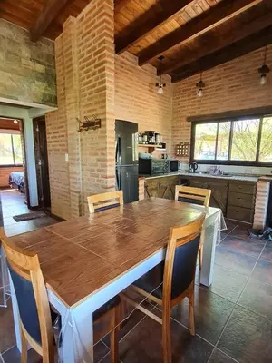 a kitchen with a large wooden table and chairs at Cabaña Flor de Lis in San Javier