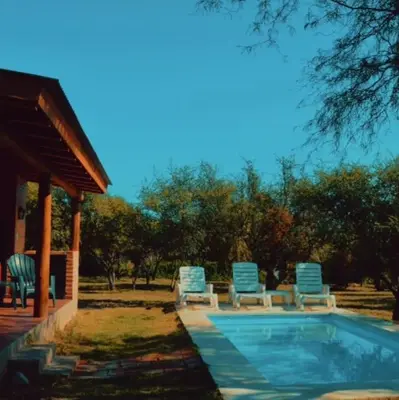 a swimming pool with chairs and a gazebo at Cabaña Flor de Lis in San Javier