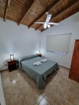 a bedroom with a bed and a ceiling fan at Cabañas MIS SUEÑOS in Merlo