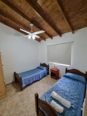 a bedroom with two beds and a ceiling fan at Cabañas MIS SUEÑOS in Merlo