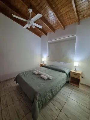 a bedroom with a bed and a ceiling fan at Cabañas MIS SUEÑOS in Merlo