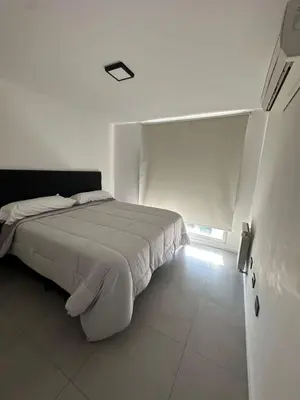 a bedroom with a bed in a white room at Em Departamento Amoblado Cordoba in Cordoba