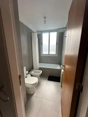 a bathroom with a toilet and a tub and a window at Em Departamento Amoblado Cordoba in Cordoba