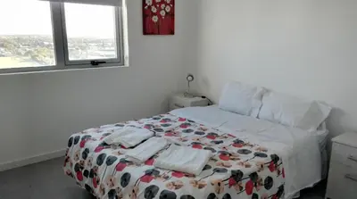 a bedroom with a bed with a comforter on it at Pampa Mora- Estadio Kempes in Cordoba