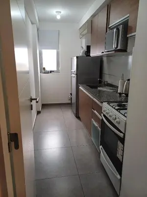 a small kitchen with a stove and a refrigerator at Pampa Mora- Estadio Kempes in Cordoba